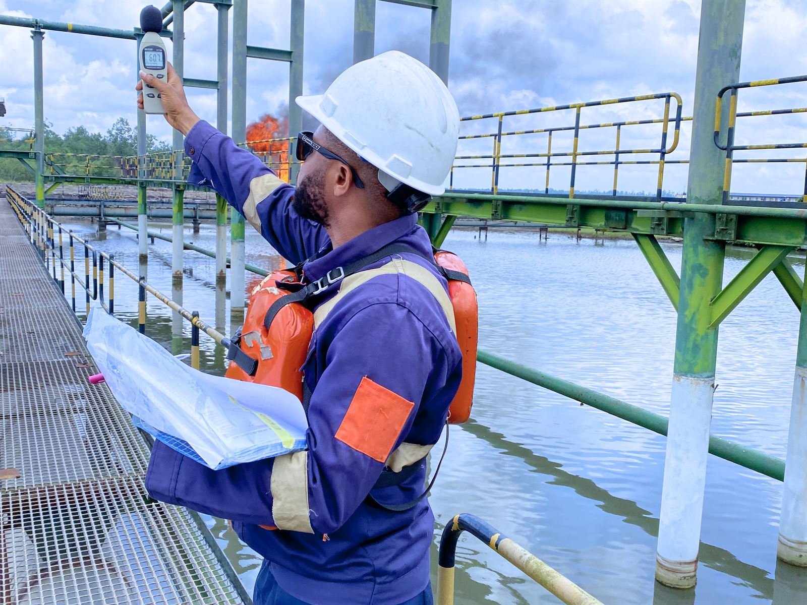 Engineer taking noise-level measurements on a jetty above the water